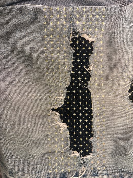 Worn jeans knee before the second repair